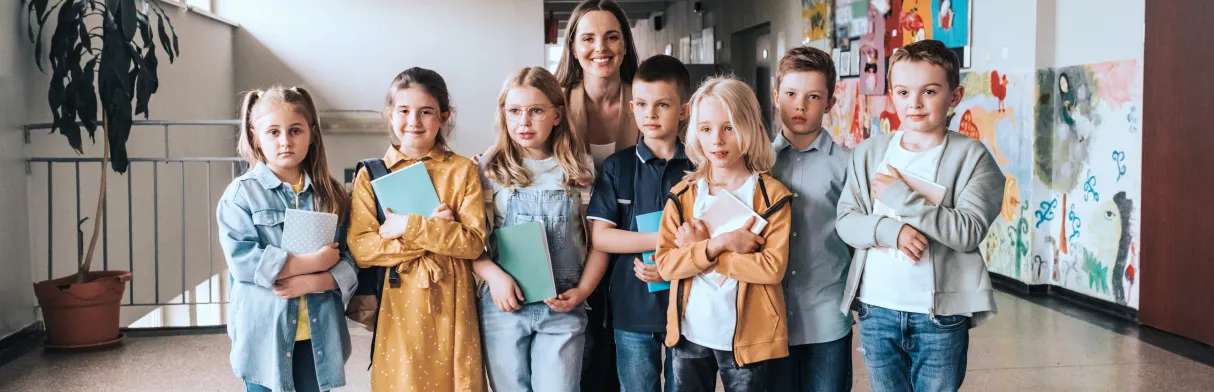 een trotse groep jonge kinderen met een basisschooldocent